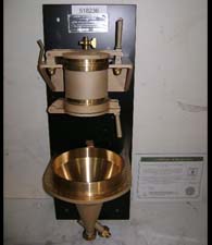 Canadian Standard Freeness Tester - Unused(!) with original certificate of calibration. As new, complete. The Canadian Standard Freeness test is designed to give a measure of the rate at which a dilute suspension of pulp may be dewatered. The drainage rate, or freeness, has been shown to be related to the surface conditions and swelling of the fibres, and is a useful index of the amount of mechanical treatment given to the pulp. The Candian Standard Freeness Tester consists of a drainage chamber and a rate-measuring funnel mounted on a support.